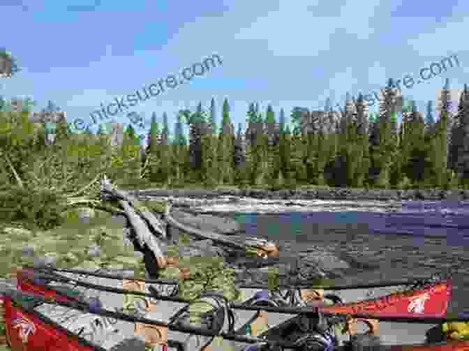 Hikers Portaging A Canoe Over A Rocky Shoreline, Surrounded By Dense Forest. By Canoe And Dog Train: The Adventures Of Sharing The Gospel With Canadian Indians (Updated Edition Includes Original Illustrations )